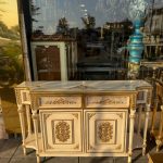 کنسول ۶ پایه منبت صنایع چوب رادین مدل 128 ساخته‌شده از چوب راش با تزئینات برنز، طراحی کلاسیک و دست‌ساز ایرانی. مناسب برای دکوراسیون لوکس، سالن پذیرایی و ورودی خانه.