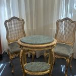 صندلی رز و میز بیضی از صنایع چوب رادین ساخته‌شده از چوب راش و تزئین‌شده با ورق طلا، طراحی کلاسیک و منبت‌کاری گل رز، مناسب دکوراسیون لوکس و مجلل، مناسب برای سالن پذیرایی، فضاهای سلطنتی و دکوراسیون نئوکلاسیک با کیفیت ساخت بالا و جزئیات ظریف.